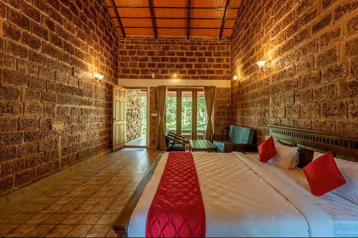 Bedroom doorway opening to the forest at Adhalakki Gudlu Cottage